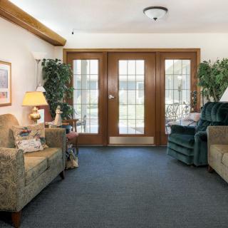 A cozy living room with sofas and wooden doors letting in natural light.