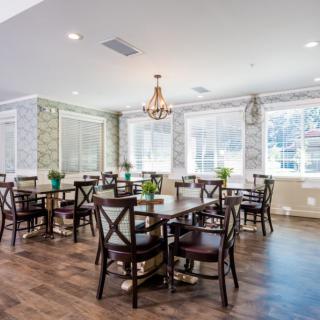 A bright and spacious dining area with tables, chairs, and a chandelier.