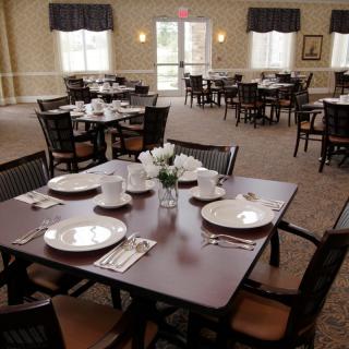 An elegantly set dining area with neatly arranged tables and chairs, ready for guests.