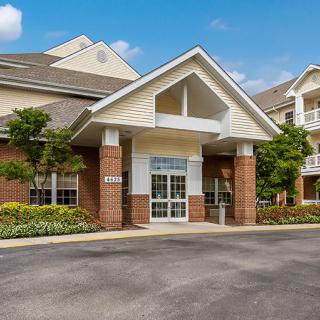 A residential building with a brick facade and landscaped entrance.