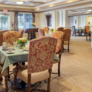 An elegantly decorated dining room featuring floral-patterned chairs and neatly set tables.