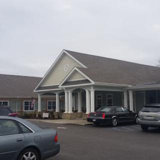 A peaceful residential building with a welcoming entrance, set against a cloudy backdrop.