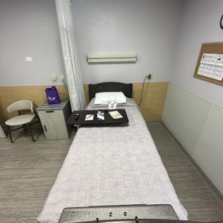 A clean and organized hospital room with a bed and medical equipment.