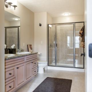 A modern bathroom featuring a large shower, vanity with sink, and a mirror.