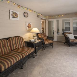 A cozy living room with striped sofas, a lamp, and decorative wall art.