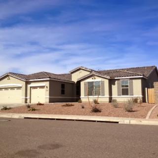 A modern single-family home with a landscaped front yard in a suburban neighborhood.