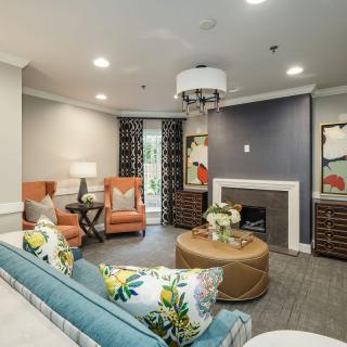 A stylish living room featuring comfortable seating, a fireplace, and modern artwork.