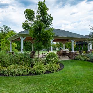 A serene outdoor pavilion surrounded by lush gardens and vibrant greenery.