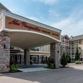 Entrance of a senior living facility with stone pillars and landscaped surroundings.