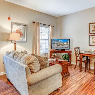 Cozy living room with a sofa, TV, and dining area.