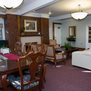 A cozy living and dining area featuring elegant furniture, warm lighting, and decorative elements.