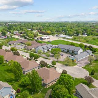 Aerial view of a suburban neighborhood with houses surrounded by greenery and trees.