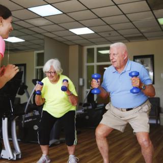 Elderly individuals engaging in a group workout session with dumbbells.