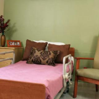 A cozy hospital room with a bed and chair.