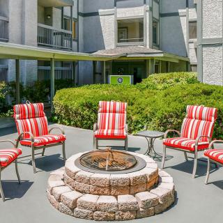 Outdoor patio with a fire pit surrounded by cushioned chairs.
