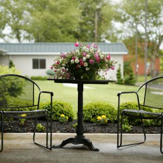 A serene outdoor seating area adorned with a flower arrangement, inviting moments of relaxation in nature.