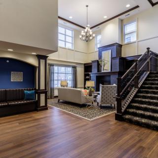 Spacious and modern living room with elegant furniture and a grand staircase.