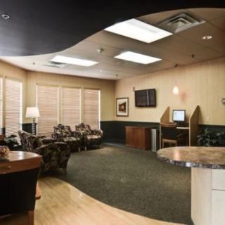 A modern waiting room with comfortable seating and warm lighting.