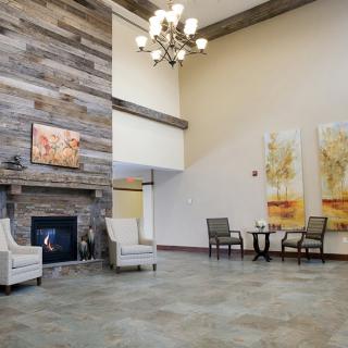 A modern lobby with a fireplace, seating area, and artwork on the walls.