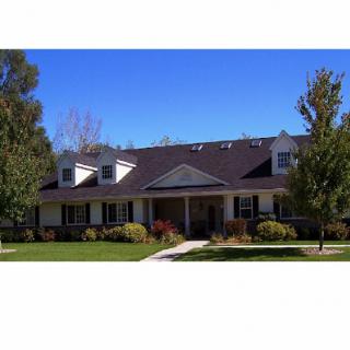 A beautiful residential house with a well-maintained front yard under a clear blue sky.