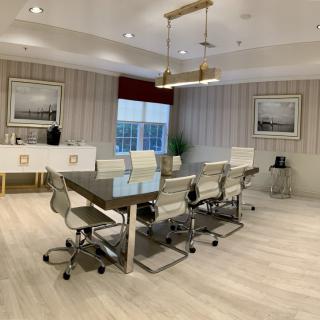 A modern conference room with a large meeting table and sleek chairs, complemented by stylish lighting and wall art.