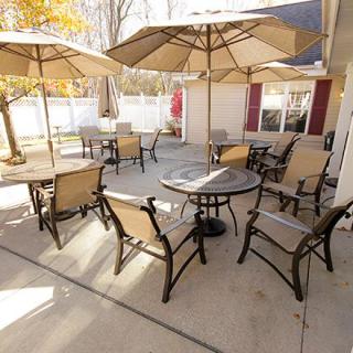A cozy outdoor patio area featuring tables and chairs with large umbrellas.