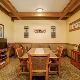 A cozy dining room with wooden table and chairs, surrounded by warm decor and soft lighting.