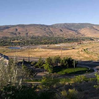 View of a valley with mountains in the background and open fields.