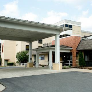 The entrance of a medical facility featuring a modern architectural design.