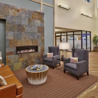 A cozy lobby area with modern furnishings and a fireplace.