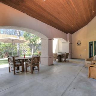 A spacious outdoor patio with seating and a garden view.