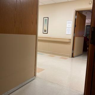 View of a hospital hallway with doors slightly ajar.