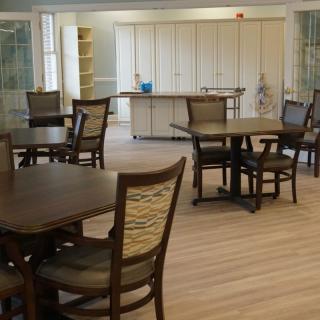 A cozy dining area with several tables and chairs arranged on a wooden floor.