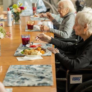 Elderly individuals enjoying a communal meal together.