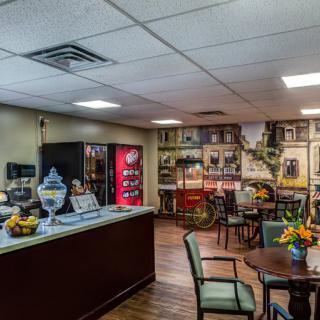 A cozy cafe interior with a seating area, beverage machines, and vintage decor.