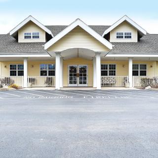 A symmetrical suburban house with a prominent entrance and multiple windows.