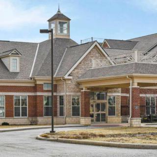 A brick building with a cupola and large windows at the entrance.