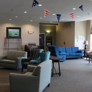 A cozy lobby area with sofas, armchairs, and decorative flags hanging from the ceiling.