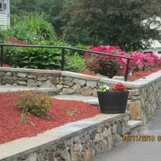 A well-maintained garden with stone walls and vibrant flowers.