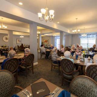 A cozy dining room filled with seniors enjoying a meal together.