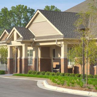A residential building with well-maintained landscaping and a clear driveway.