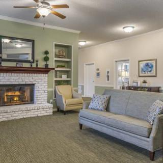 A cozy living room with a fireplace, sofa, and armchair.