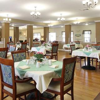 A spacious dining area with neatly arranged tables and chairs, featuring elegant decor and soft lighting.