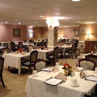 An elegantly arranged dining room with tables set for a formal meal.