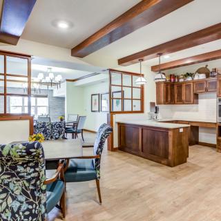 A modern open-concept kitchen and dining area featuring wooden beams and stylish furnishing.