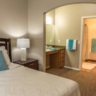 A cozy bedroom with a view of an adjoining bathroom.