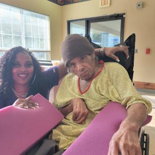 A moment of connection and support between two individuals in a caring environment.