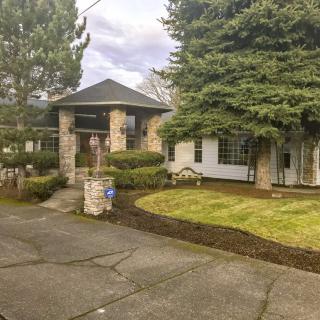 A well-maintained suburban house with a driveway and landscaped front yard.
