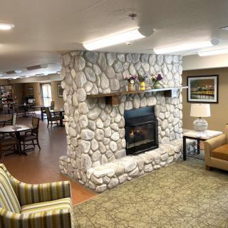 A cozy living room with a stone fireplace and comfortable seating.