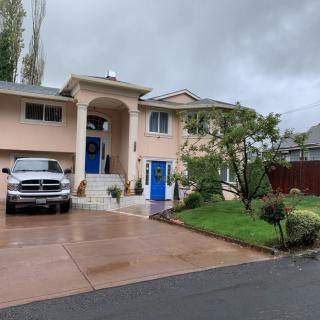 A suburban house with a driveway and car on a cloudy day.